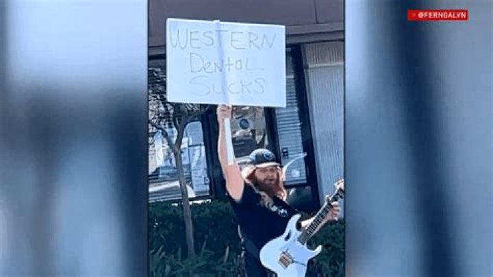 Man Protests Dental Office With Guitar Solo Outside